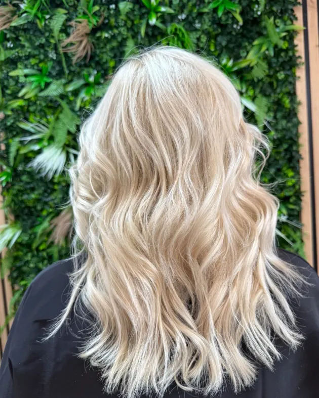 Blond balayage lumineux sur cheveux mi-longs ondulés — coiffeur coloriste à Calais